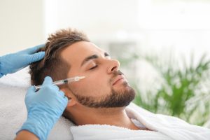 man receiving botox injection on face while lying down in spa setting