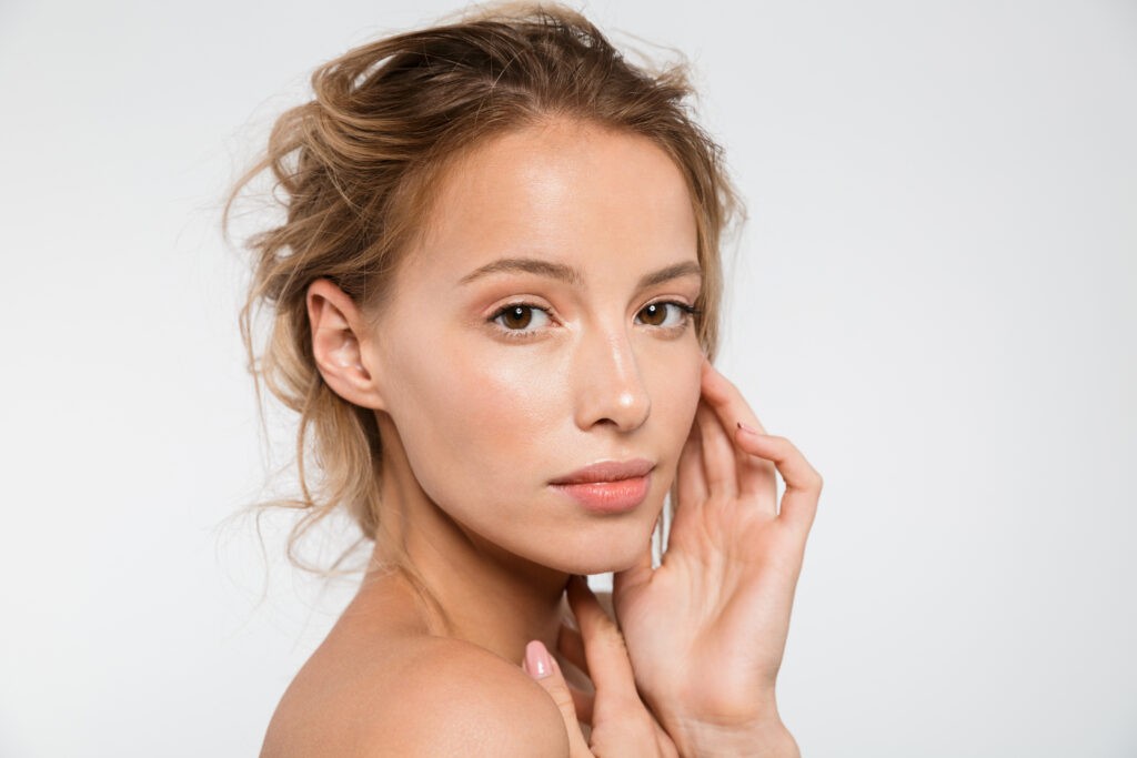 Beauty portrait of an attractive young topless blonde woman isolated over white background, posing