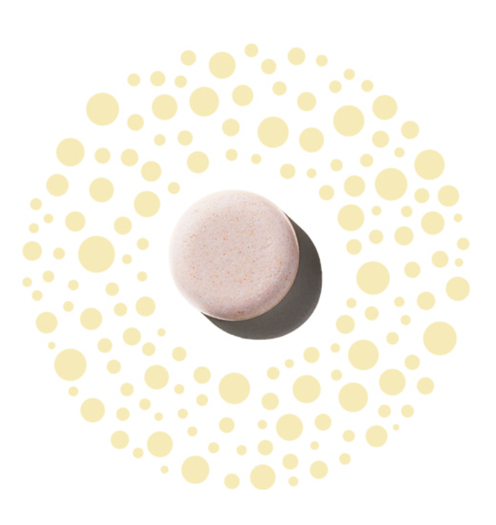 close up of a single pale peach colored Oxypod placed on a background of scattered soft yellow dots for Oxy Illuminate treatment