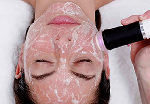 woman receiving a foaming facial treatment with an Oxypod device